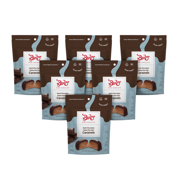 Six pouches of Bixby Chocolates Dark Chocolate Sea Salted Caramels are arranged in two rows on a plain white background, with packaging featuring images of the chocolate caramels and the Bixby Chocolates logo.