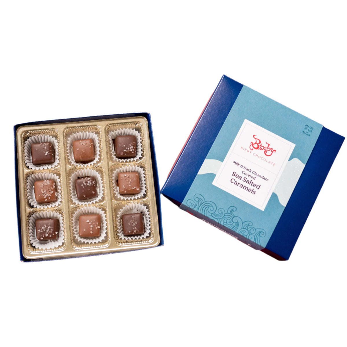 An open blue Bixby Chocolates Milk & Dark Collection Sea Salted Caramel Gift Box displays nine assorted caramel chocolates in paper cups, with the lid reading “Sea Salted Caramels.”.
