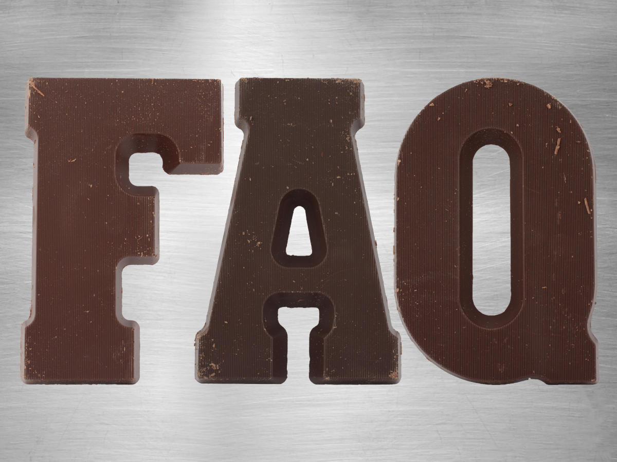 Capital letters FAQ made of chocolate are placed side by side on a brushed metal background.