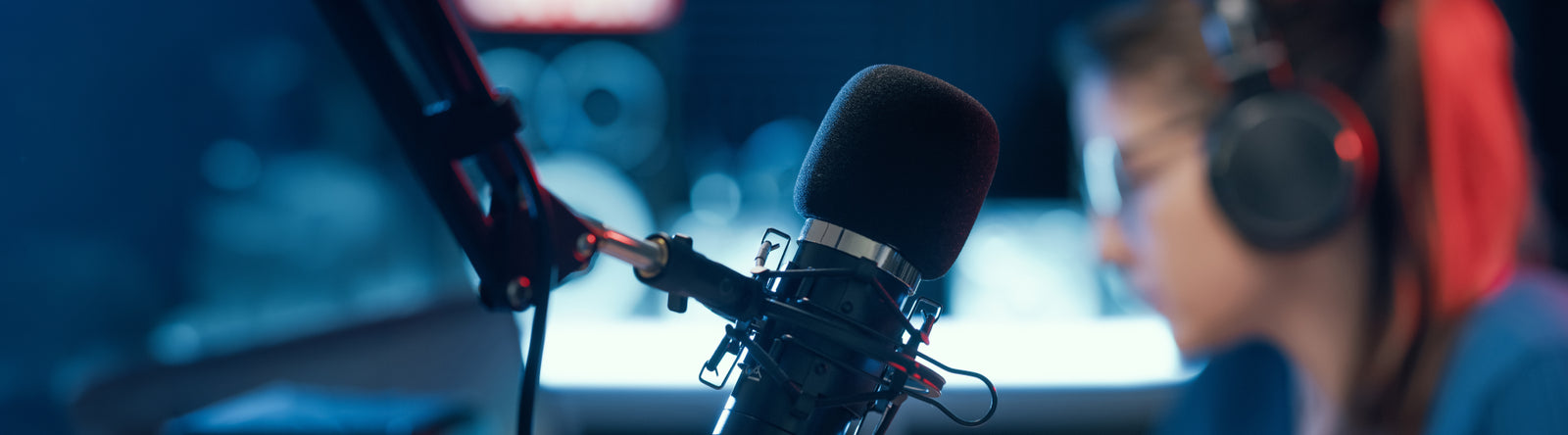 Woman in headphones next to a microphone