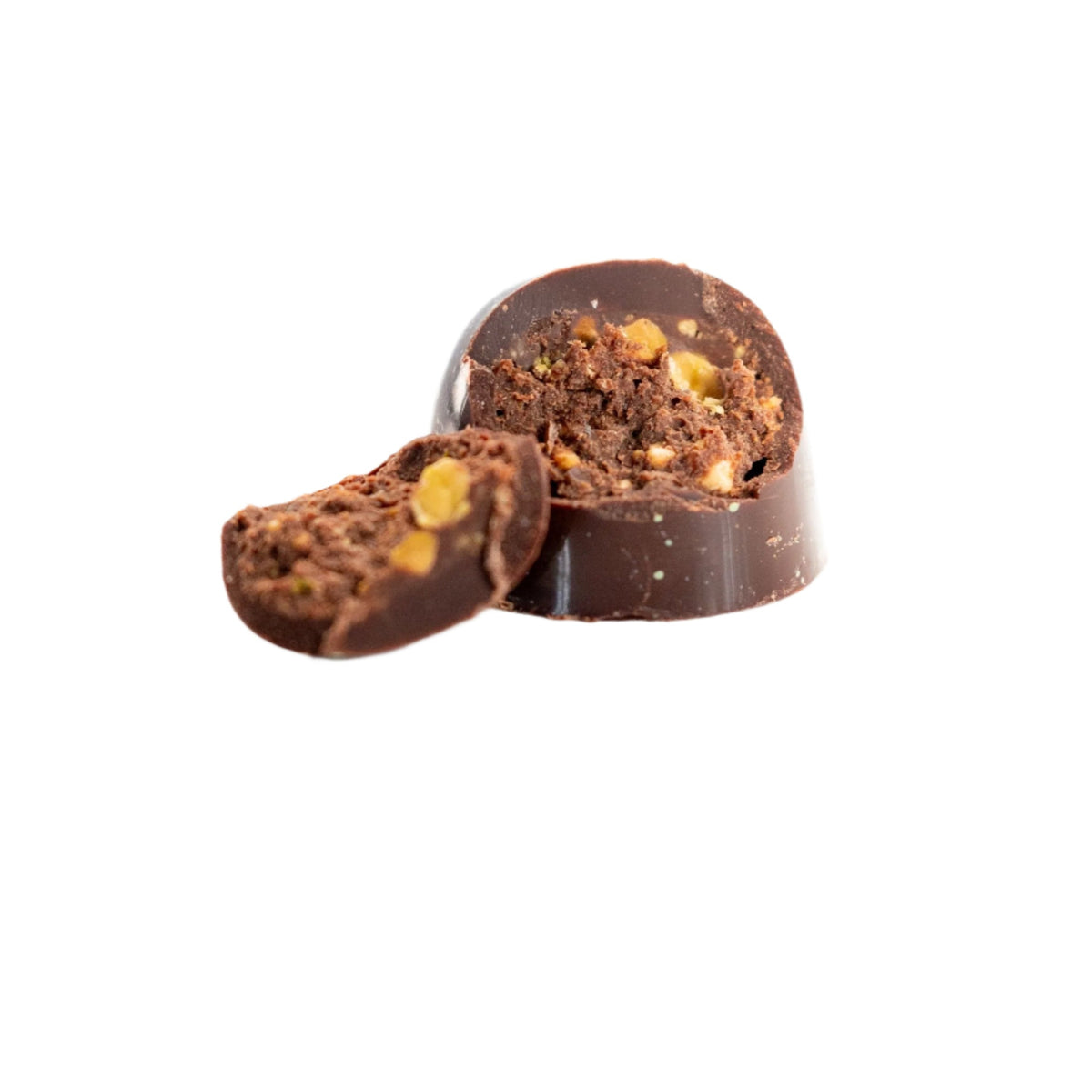 A round Bixby Chocolates Pistachio Dark Chocolate Bon Bon (Vegan), partially sliced to show its textured plant-based filling with visible nuts, is displayed against a plain white background.
