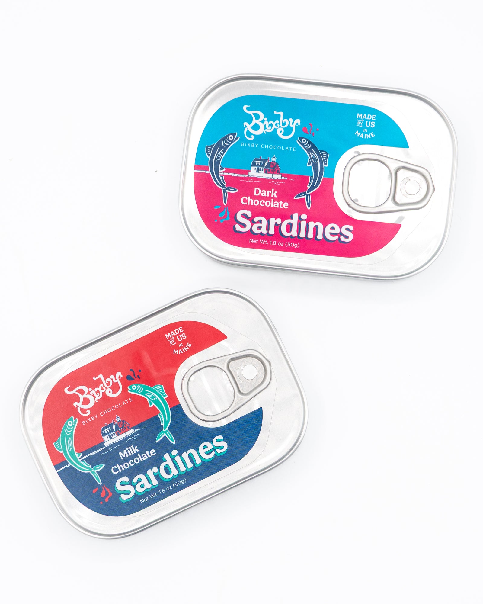 Two sardine-style tins labeled Chocolate Sardines, Tinned from Bixby Chocolates—with playful fish graphics and bright colors—make a whimsical Maine souvenir filled with artisanal chocolate treats.