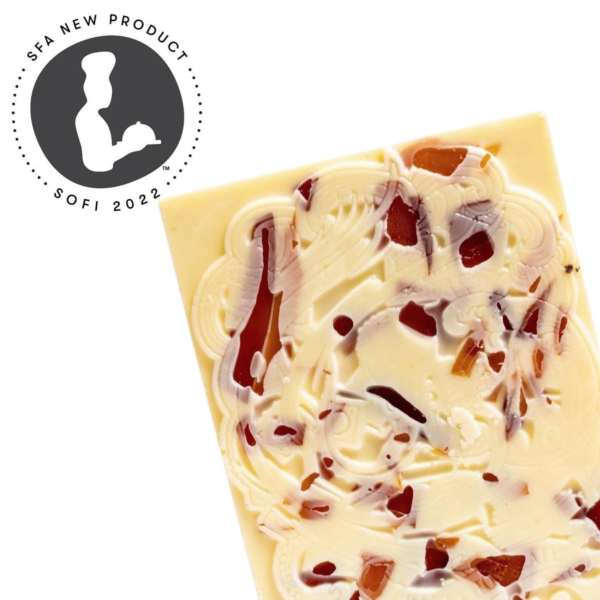 The Bixby Chocolates Organic Crème Brûlée White Chocolate Bar, decorated with fruit or nut pieces, is shown next to a circular Sofi 2022 SFA New Product award logo with a stylized chef holding a platter.