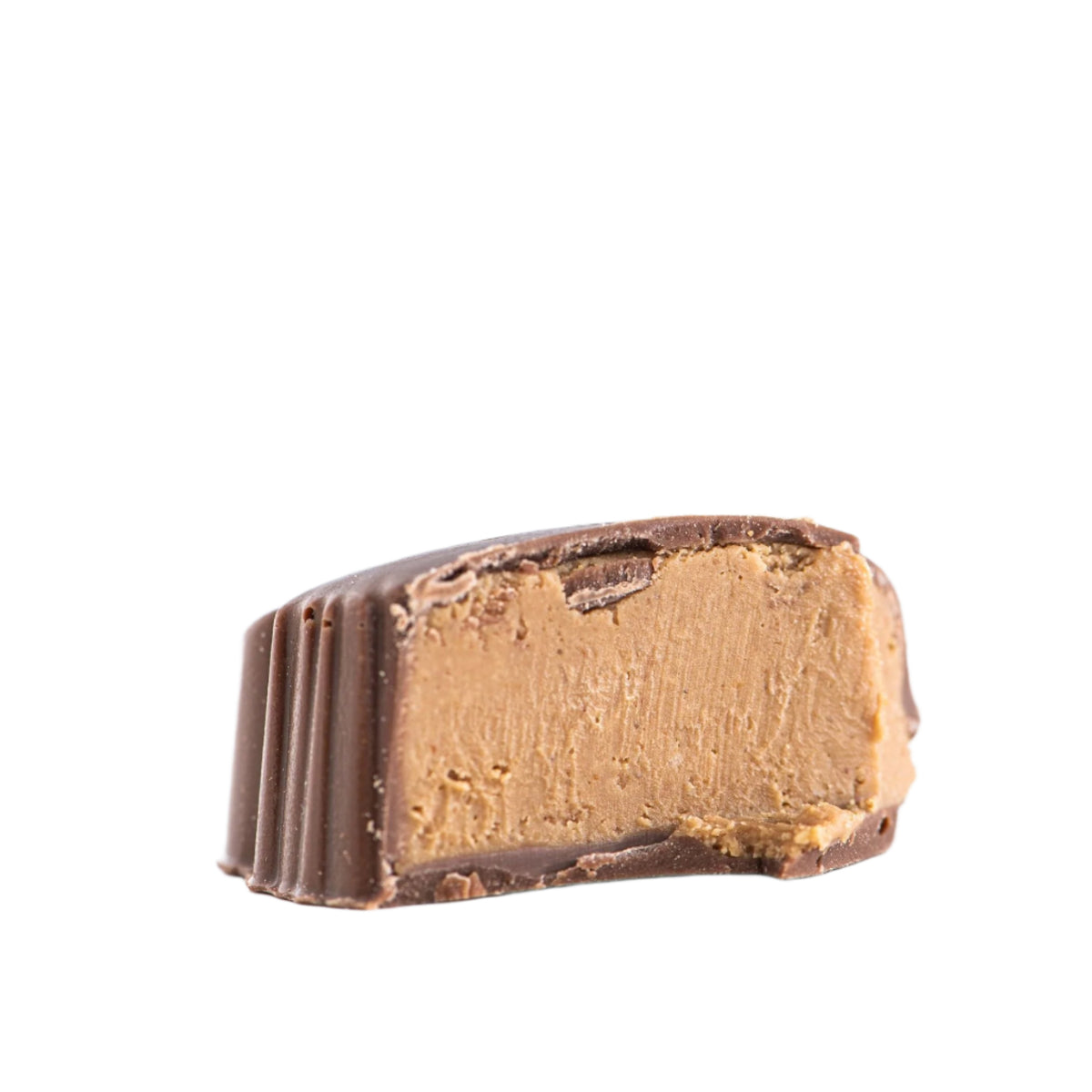 A half-eaten Bixby Chocolates Peanut Butter Lobster Claws candy shows its smooth, light brown peanut butter ganache filling, isolated on a white background.