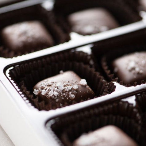 Close-up of the Bixby Chocolates Dark Chocolate Sea Salted Caramels Gift Box, featuring artisanal caramels in dark paper wrappers, each topped with sea salt.