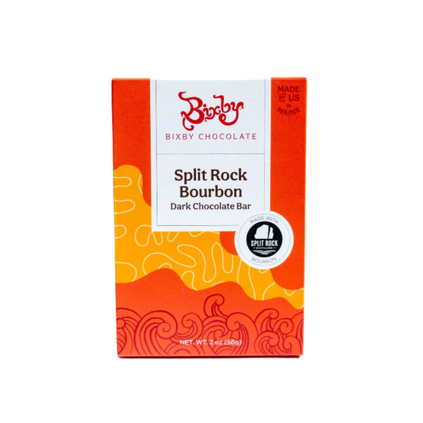 A 2 oz (56g) box of Bixby Chocolates Organic Split Rock Bourbon Bar, made with single-origin cacao, comes in red and orange wavy packaging labeled “Made in Maine, USA.”.