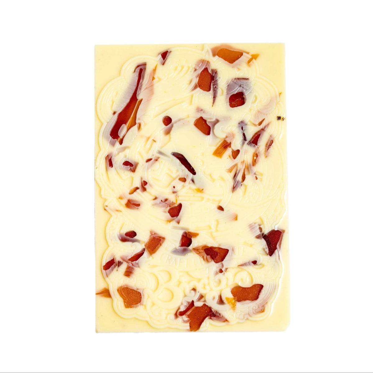 The Bixby Chocolates Organic Crème Brûlée White Chocolate Bar features ornate embossed designs and scattered pieces of dried fruit, made from organic ingredients, displayed on a white background.